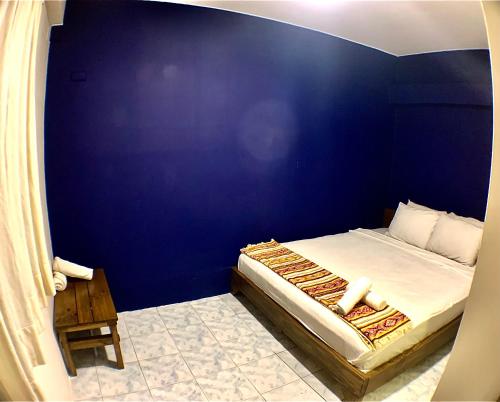 a blue bedroom with a bed with a blue wall at Hotel Montañita in Montañita