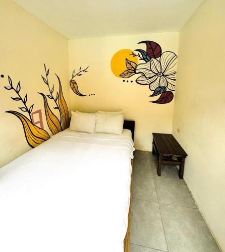 a bedroom with a bed with a flower mural on the wall at Hotel Montañita in Montañita