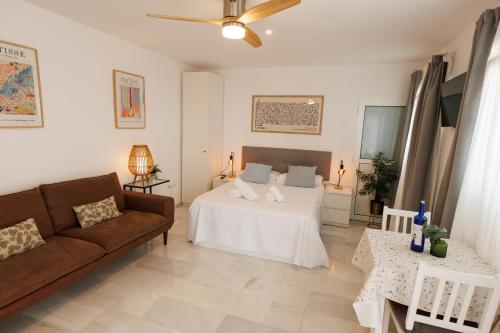 ein Wohnzimmer mit einem Bett und einer Couch in der Unterkunft El ático de Osario 5 con terraza - Great location in Córdoba