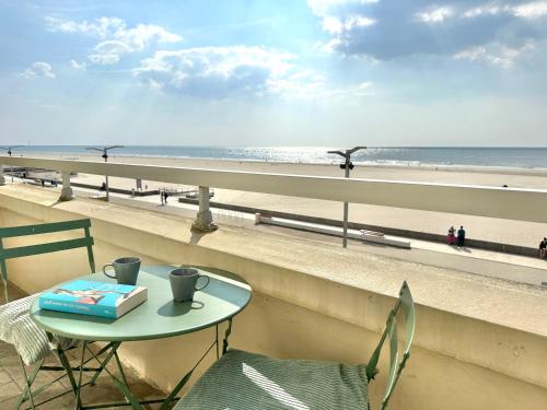 une table et des chaises sur un balcon avec vue sur la plage dans l'établissement Sea View and balcony with 2 bedrooms in Berck-Plage, à Berck-sur-Mer
