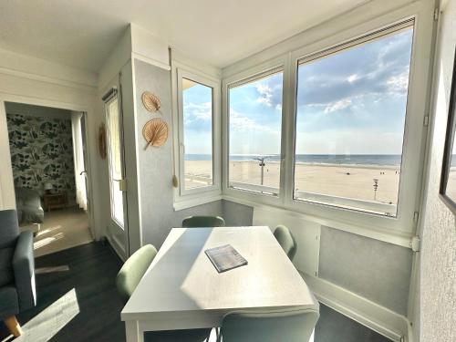 une salle à manger avec une table et une vue sur la plage dans l'établissement Sea View and balcony with 2 bedrooms in Berck-Plage, à Berck-sur-Mer