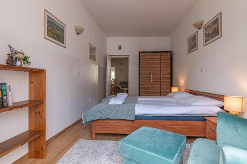 een slaapkamer met een groot bed en een stoel bij Apartament u Renaty in Krynica Zdrój