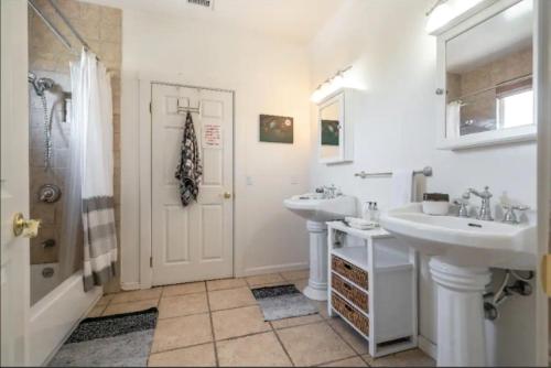 a white bathroom with two sinks and a shower at Your Vacation Home in the Hills of Studio City in Studio City