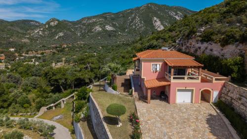 a house on a hill with mountains in the background at TheaHouse in Pythagoreio