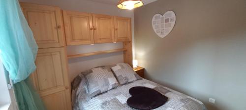 - une chambre avec un lit doté d'un chapeau noir dans l'établissement Appartement 6 personnes au pied des pistes, à Saint-Jean-dʼAulps