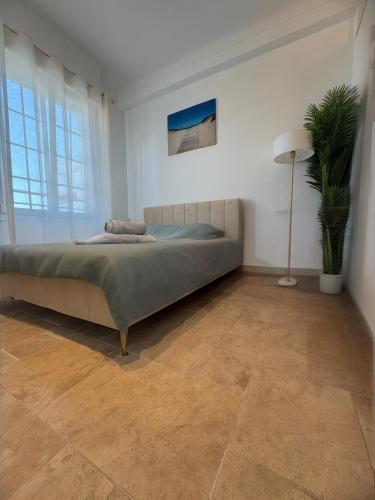 une chambre avec un lit et une plante en pot dans l'établissement Appartement T3 grand standing à Juan Les Pins, à Antibes