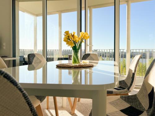 une table à manger avec des chaises et un vase de fleurs dans l'établissement Meilleure vue de Bordeaux, à Bordeaux