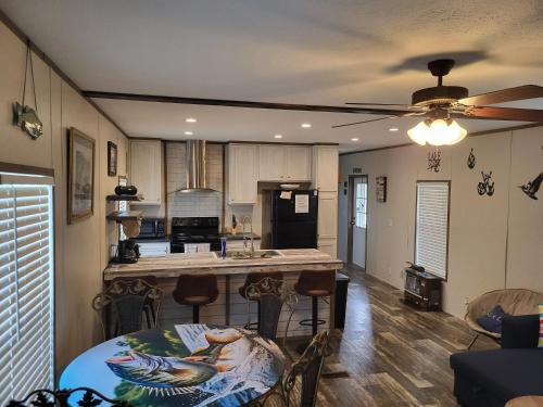 a kitchen with a table and a ceiling fan at The Tackle Box in Many