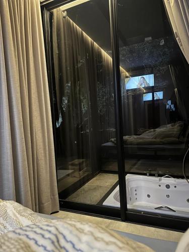 a reflection of a bath tub in a window at Casa de Vidro na Montanha in Cambuí