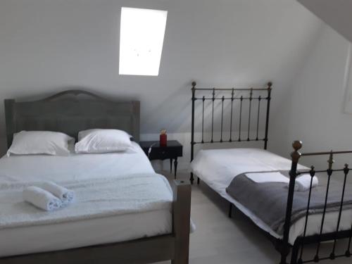 une chambre avec deux lits et une fenêtre dans l'établissement Maison Marguerite, à Loches
