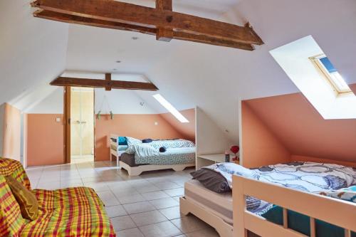 DrulheにあるLe Nid du Colibriの屋根裏のベッドルーム(ベッド2台、ソファ付)