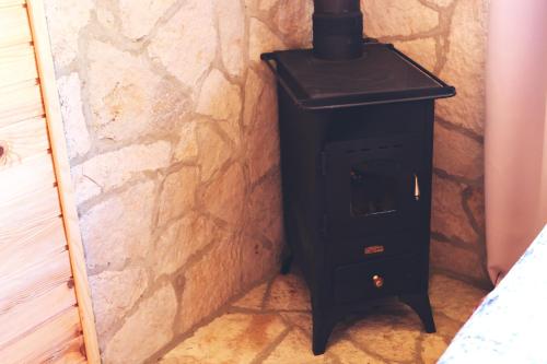 a black stove in the corner of a room at Kanjon 987 in Podgrad