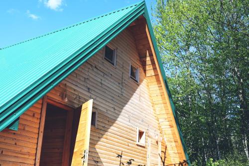 a large wooden building with a green roof at Kanjon 987 in Podgrad
