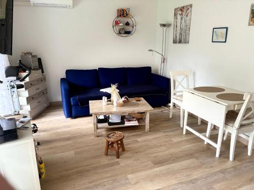 un salon avec un canapé bleu et une table dans l'établissement La renaissance au calme, à Gorbio