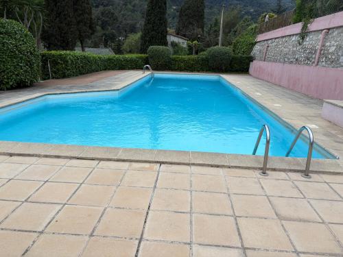 une piscine avec de l'eau bleue dans une cour dans l'établissement La renaissance au calme, à Gorbio