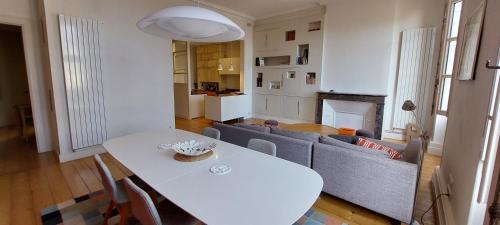 un salon avec une table blanche et un canapé dans l'établissement Burdigala Homes - Appart rue Ausone, à Bordeaux