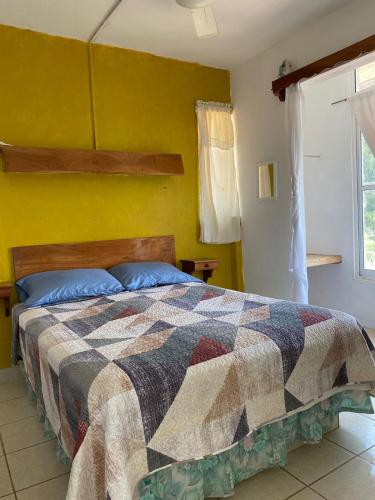 a bedroom with a bed with a colorful quilt at La Cabaña del Lago in Catemaco