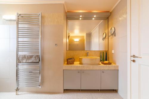 ein Badezimmer mit Waschbecken und Spiegel in der Unterkunft Villa Blue Horizon in Kalívia Thorikoú