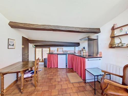 Il comprend une cuisine avec une table en bois et un comptoir. dans l'établissement Nid perché avec terrasse et vue Centre Village, à Cotignac