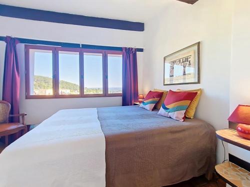 - une chambre avec un grand lit et des rideaux violets dans l'établissement Nid perché avec terrasse et vue Centre Village, à Cotignac