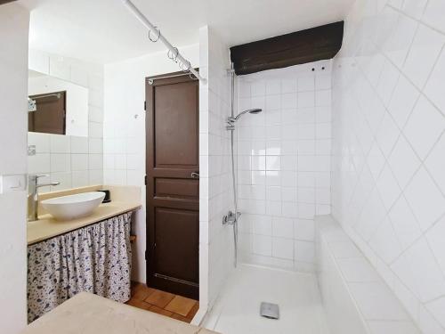 une salle de bain blanche avec un lavabo et une douche dans l'établissement Nid perché avec terrasse et vue Centre Village, à Cotignac