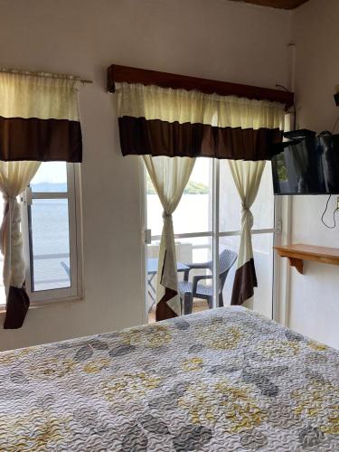 a bedroom with a bed and a large window at La Cabaña del Lago in Catemaco