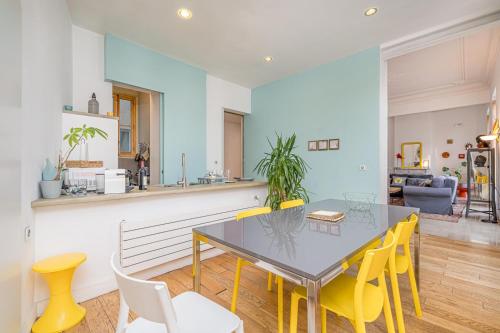 une salle à manger avec une table et des chaises jaunes dans l'établissement Vaste et bel appartement au cœur de Marseille, à Marseille