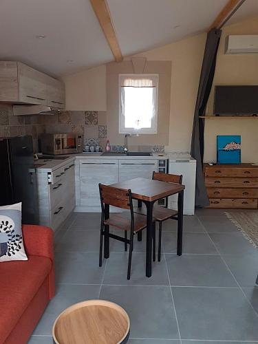 une cuisine avec une table et des chaises dans une pièce dans l'établissement Kaliméra, à Mouriès