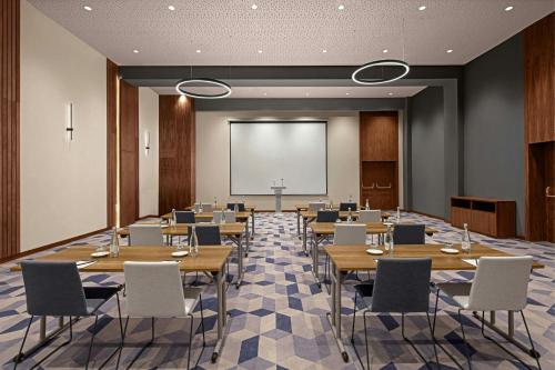 a conference room with tables and chairs and a projection screen at Courtyard by Marriott Casablanca Downtown in Casablanca