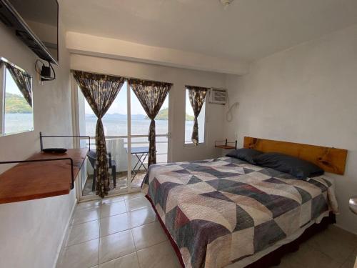 a bedroom with a bed and a large window at La Cabaña del Lago in Catemaco