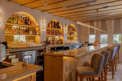 a bar with a row of bar stools at Donatella Boutique Hotel in Miami Beach