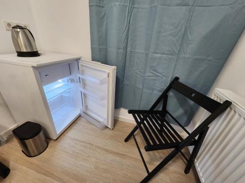 a black chair in a room with a refrigerator at Aparthotel B & L in Bremen
