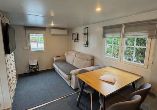 una sala de estar con un sofá y una mesa en Ossau Du Lit, en Gère-Belesten