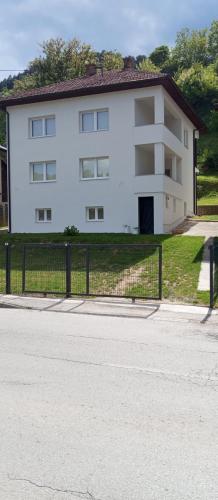 a white building with a fence in front of it at Apartmani Mušinbegović in Visoko