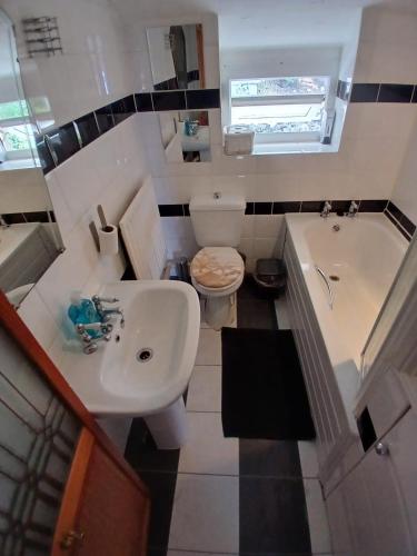 a bathroom with a sink and a tub and a toilet at Seaview cottage North Wales in Penmaen-mawr