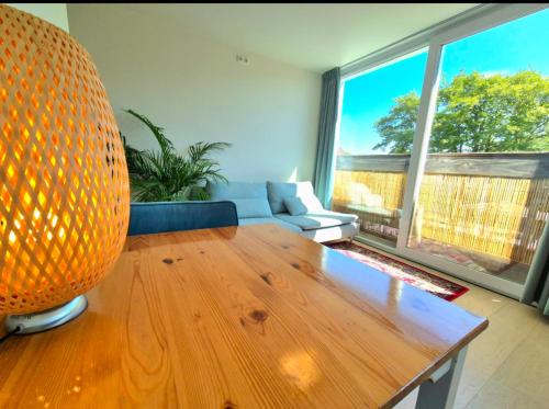 a living room with a wooden table and a couch at Welkom Op Texel privé kamer op het zuiden in De Koog