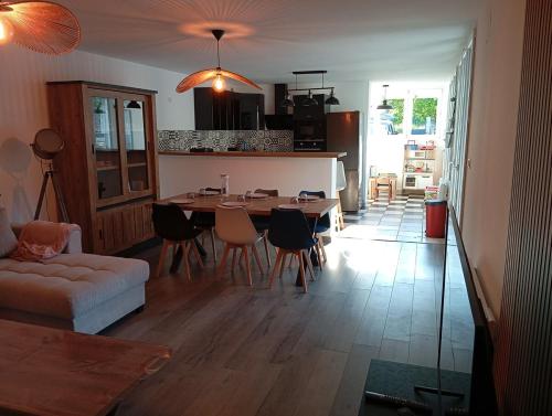 un salon avec une table et des chaises et une cuisine dans l'établissement Magnifique hébergement en Rez de jardin, à Joigny-sur-Meuse