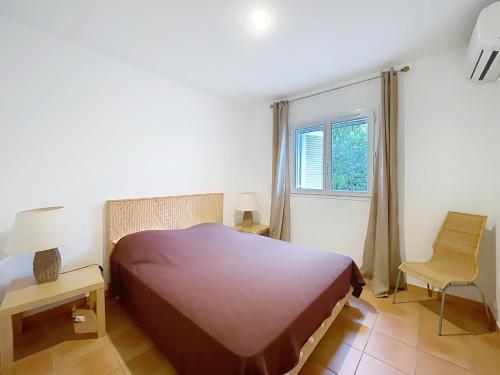 une chambre avec un lit, une chaise et une fenêtre dans l'établissement Villa Cala Rossa 3 chambres, à Lecci