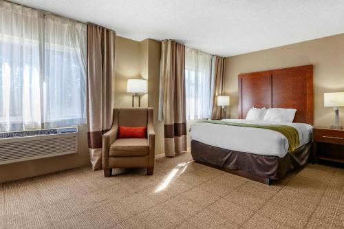 a hotel room with a bed and a chair at Comfort Inn Rhinelander in Rhinelander