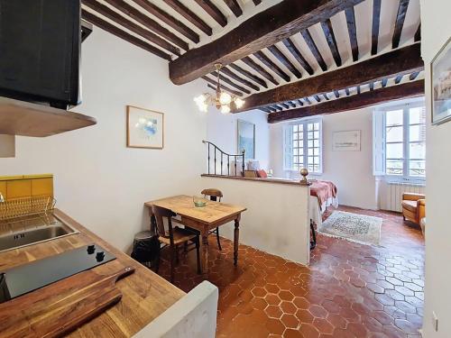 a kitchen with a wooden table in a room at Studio style provençal in Cotignac