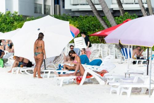 a group of people sitting on the beach at SEASUNBEACH Maafushi in Maafushi