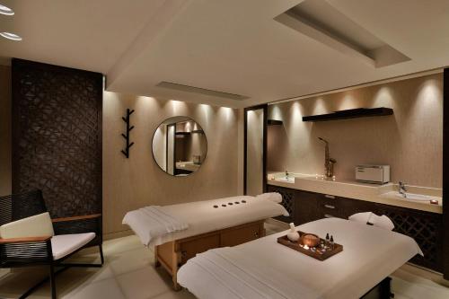 a hospital room with two beds and a mirror at Four Points by Sheraton Al Ain in Al Ain