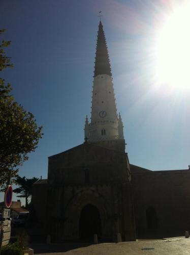 a church with a clock tower on top of it at Mamaisondouce in Saint-Clément-des-Baleines