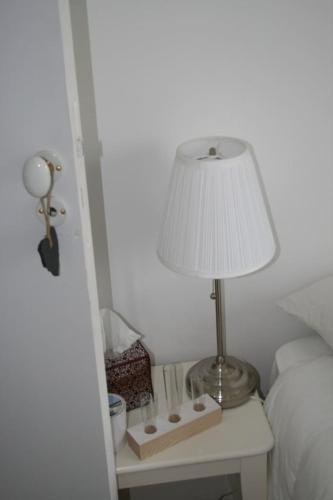 a lamp on a table next to a bed at Mamaisondouce in Saint-Clément-des-Baleines