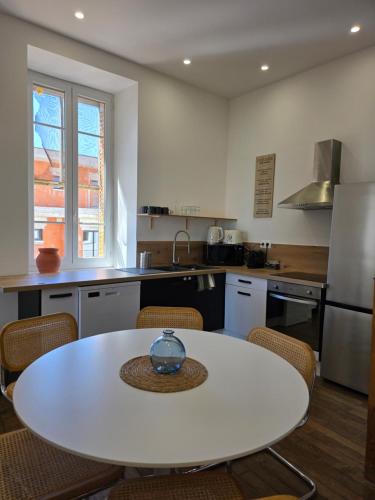 - une cuisine avec une table blanche et des chaises dans l'établissement Chez Rose, à Montélimar