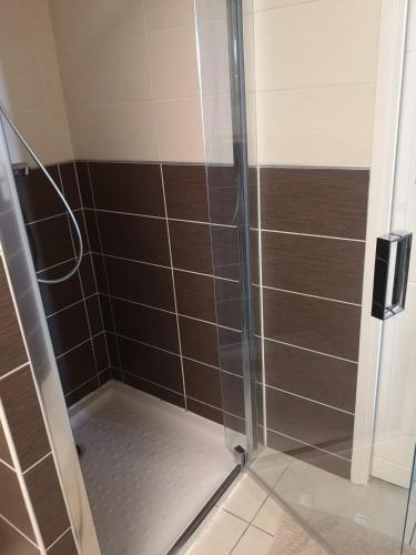 une douche avec une porte vitrée dans une salle de bain dans l'établissement appartement 2 pieces avec parking ds résidence, à Palavas-les-Flots