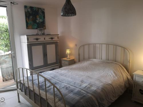 une chambre avec un lit, une commode et une fenêtre dans l'établissement appartement 2 pieces avec parking ds résidence, à Palavas-les-Flots