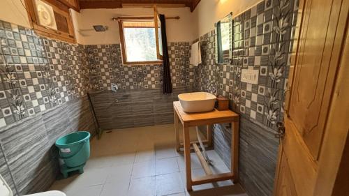 a bathroom with a sink on a wooden table at The mysteryworld a-wooden tree cottage jibhi in Banjār