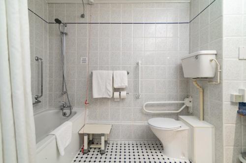 a bathroom with a toilet and a tub and a sink at Holiday Inn Ashford - North A20 by IHG in Ashford