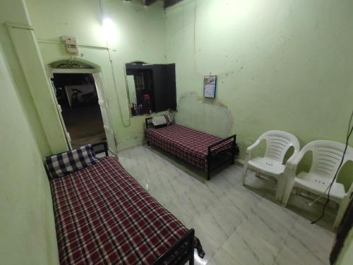 une vue aérienne d'une pièce avec deux lits et deux chaises dans l'établissement Mohak Yatri Nivas मोहक यात्री निवास, à Kolhapur